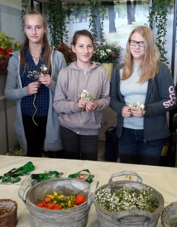 drei Mädchen halten Blumen